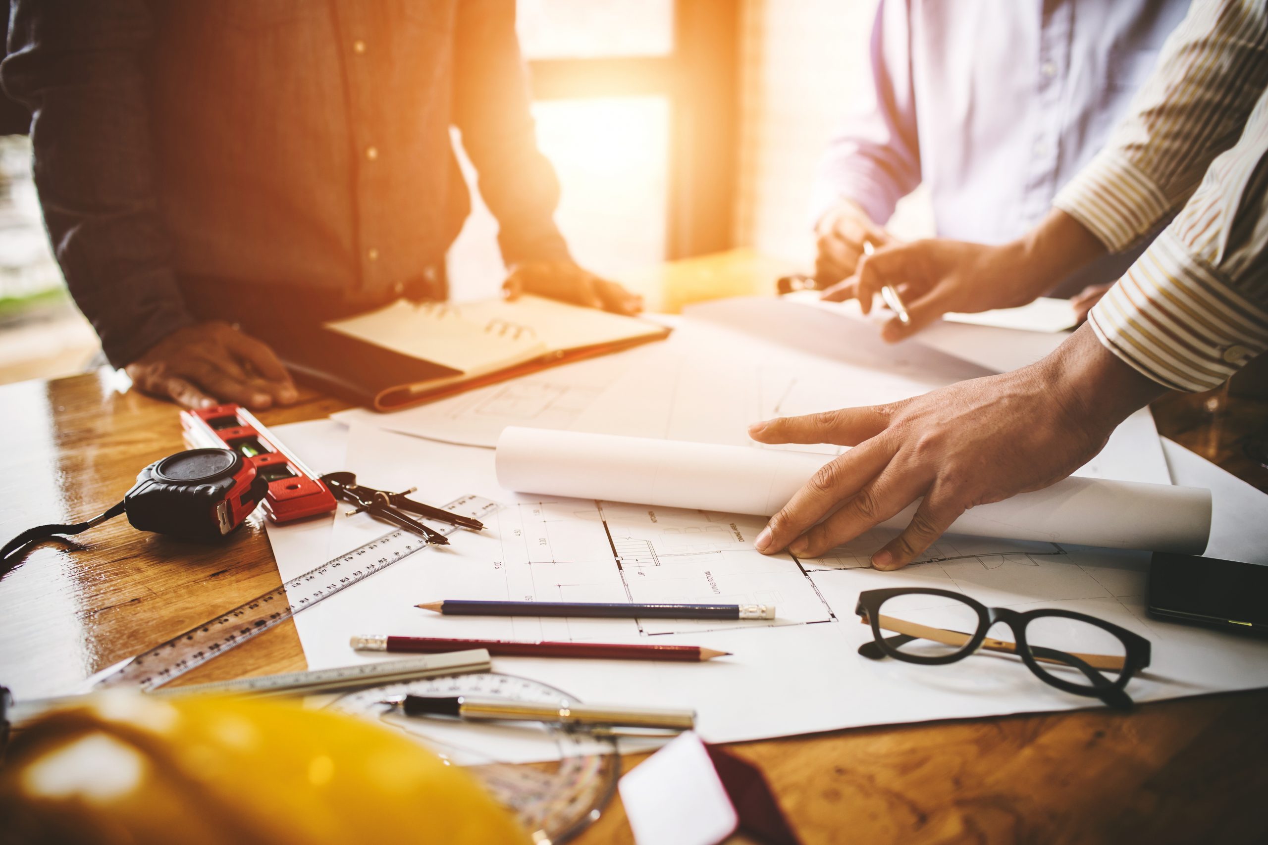 Consultation between colleagues, engineering team to check the blueprint used to build commercial buildings for joint ventures.